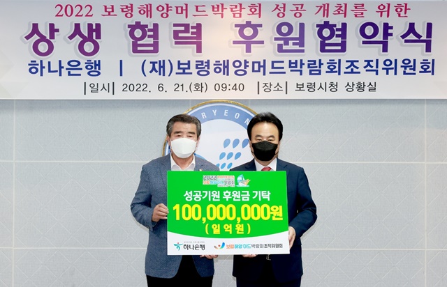 2022보령해양머드박람회 조직위원회 공동조직위원장인 김동일 보령시장(왼쪽)과 하나은행 이성진 총괄대표(오른쪽)은 21일 보령시청에서 후원협약을 맺었다. / 보령해양머드박람회 조직위원회 제공
