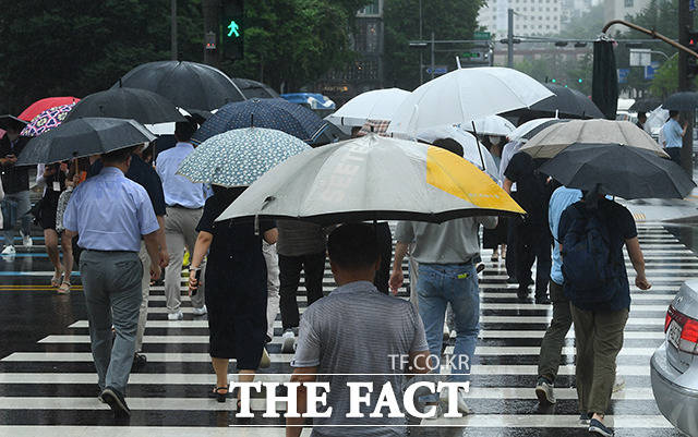 서울 전역에 호우경보가 발효된 30일 오전 서울 종로구 광화문역 일대의 시민들이 우산을 쓰고 발걸음을 재촉하고 있다. /이동률 기자