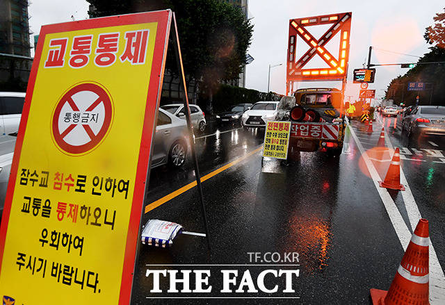 서울을 포함한 수도권에 호우특보가 발효된 가운데 30일 오전 서울 서초구 잠수교에서 경찰들이 차량을 통제하고 있다. /이선화 기자
