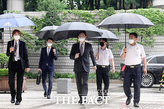 우산을 들고 덤덤한 모습으로 법원 출석하는 이 부회장.