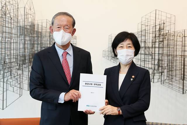 허창수 전경련 회장이 한화진 환경부 장관에게 환경 규제 개혁 과제 책자를 전달하고 있다. /전경련 제공
