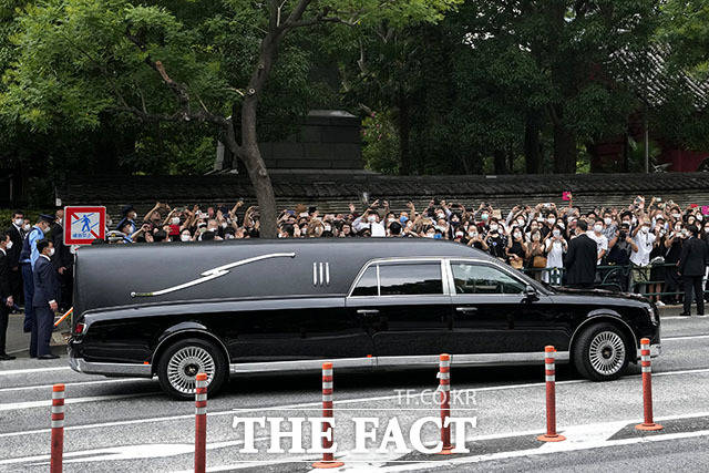 아베 전 총리의 시신 운구 차량이 장례식을 마친 뒤 의장대의 배웅을 받으며 사찰을 떠나고 있다.