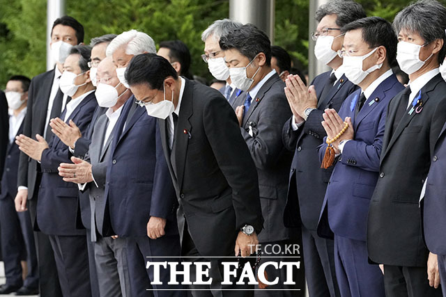 일본 총리 관저에 도착한 아베 전 총리의 시신 운구 차량을 향해 합장 인사하는 기시다 후미오(가운데) 총리.