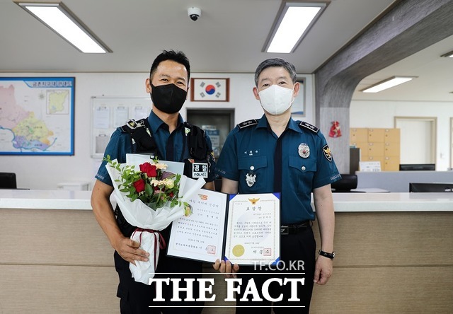 이문수 경기북부경찰청이 파주경찰서 금촌지구대를 직접 방문, 스마일세이버로 선정된 정재득 경위에게 인증서와 배지를 수여한 뒤 기념촬영을 하고 있다. /경기북부경찰청 제공