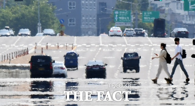 월요일인 25일 전국은 비가 그친 뒤 찜통더위로 대단히 무덥겠다. 시민들이 열기가 솟아오르는 횡단보도를 건너고 있다. / 더팩트DB