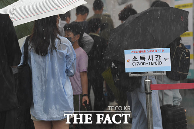 중부지방에 장대비가 예보된 가운데 8일 오후 서울시 중구 서울역 광장에 설치된 임시선별검사소에 코로나19 검사를 받으러 온 시민들이 비를 피하고 있다. /박헌우 인턴기자