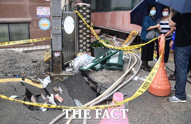 서울 관악구 신림동 반지하 주택에서 간밤에 쏟아진 폭우로 사망 사고가 발생한 가운데 9일 오전 사고 주택 앞에 싱크홀이 발생해 있다.