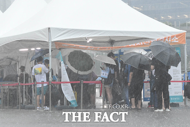 지난 8일 오후 서울시 중구 서울역 광장에 설치된 임시선별검사소에 코로나19 검사를 받으러 온 시민들이 비를 피해 대기 중이다./박헌우 인턴기자