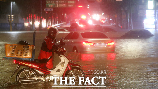 서울과 수도권 등 중부 지방을 중심으로 많은 비가 내린 8일 오후 서울 강남구 일대 도로가 침수돼 차량이 잠겨 있다. /뉴시스