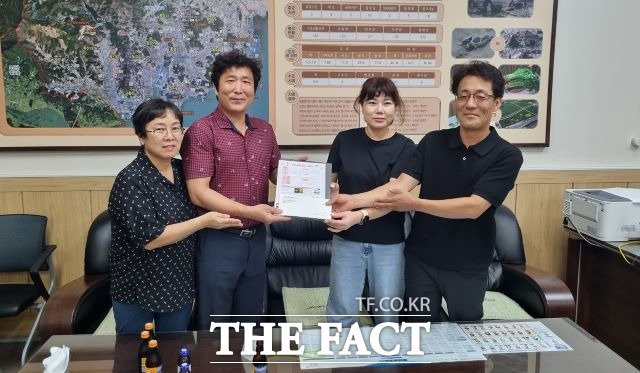 순천CF유기농원 대표 이정씨(오른쪽)가 지난 19일 별량면행정복지센터를 찾아 김 군을 도와달라며 김종환 면장(왼쪽 두번째)에게 현금 150만 원을 기탁하고 있다. /순천시 제공