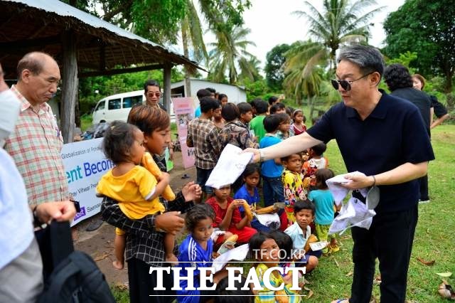 오주섭 이사장이 쁘레이카 마을 천사보금자리 애육원 원생들과 주민 아이들에게 옷을 나눠주고 있다./프놈펜=김채은 기자