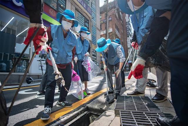 포스코 임직원으로 구성된 싸리비봉사단이 서울 강남 포스코센터와 선릉역에서 빗물받이에 쌓인 각종 쓰레기를 집중적으로 제거하는 봉사활동을 펼쳤다. /포스코 제공