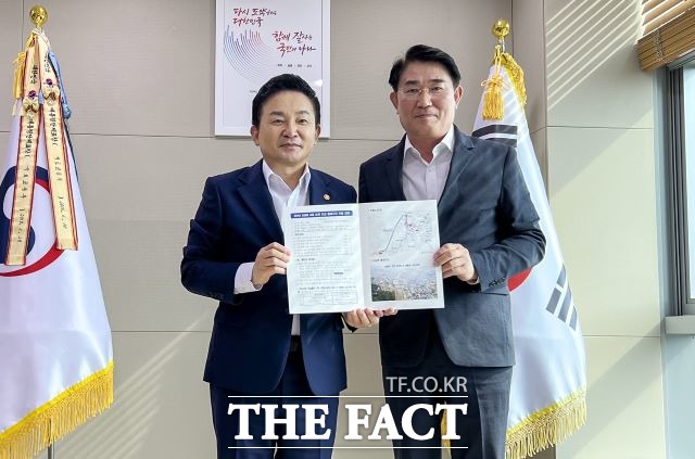 노관규 순천시장이 26일 원희룡 국토교통부 장관을 만나 ‘순천 도심을 관통하는 경전선 전철화 사업 노선 변경을 요구했다. 노 시장과 원 장관은 면담을 마친 후 경전선 사업 설명 자료집을 들고 기념사진을 남겼다. /순천시청 제공