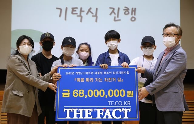 배장환 경주사업총괄본부 건전화추진실장(맨오른쪽)이 강옥희 광명YMCA 사무총장(맨왼쪽)과 참여 학생들에게 ‘마음 따라가는 자전거 길’ 프로그램 운영을 위한 기부금을 전달하고 있다./경주사업총괄본부 제공