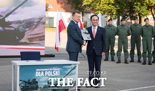 이용배 현대로템 사장이 지난 26일(현지시각) 열린 K2 전차 수출계약식에서 폴란드에서 마리우시 브와시착 폴란드 부총리 겸 국방장관과 악수하고 있다. /현대로템