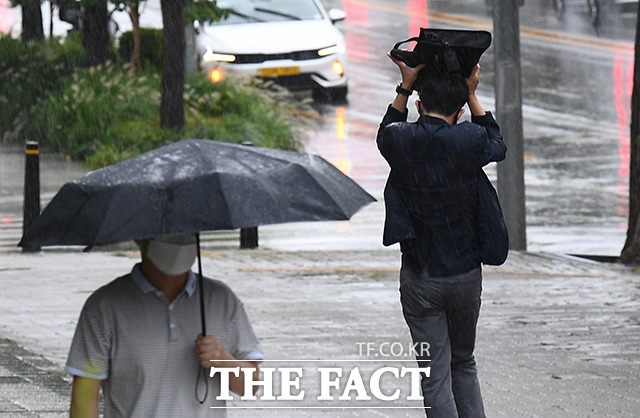 수도권에 집중호우가 예보된 30일 오전 서울 영등포구 여의도공원 일대의 시민들이 우산을 쓰고 발걸음을 재촉하고 있다. /이동률 기자