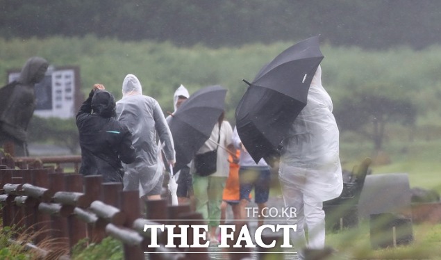 비바람이 부는 2일 오후 제주 서귀포시 대정읍 송악산에 우산을 쓴 관광객들이 걸어가고 있다. /제주=뉴시스