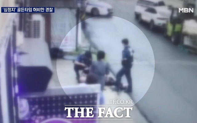 지난달 30일 전북 군산의 한 골목길에서 출동한 경찰이 심정지로 쓰러진 50대 남성을 지켜보고 있다. MBN 보도화면 캡처