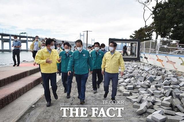 한덕수 국무총리가 8일 부산 수영구 민락 수변공원 태풍 피해 현장을 방문해 현황을 보고받고 있다. /총리실 제공