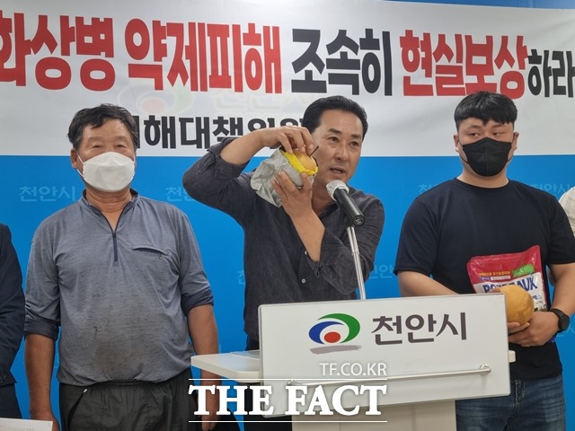 유영오 피해대책위원장이 약흔이 발생한 배를 들어보이며 피해를 호소하고 있다. / 천안=김경동 기자