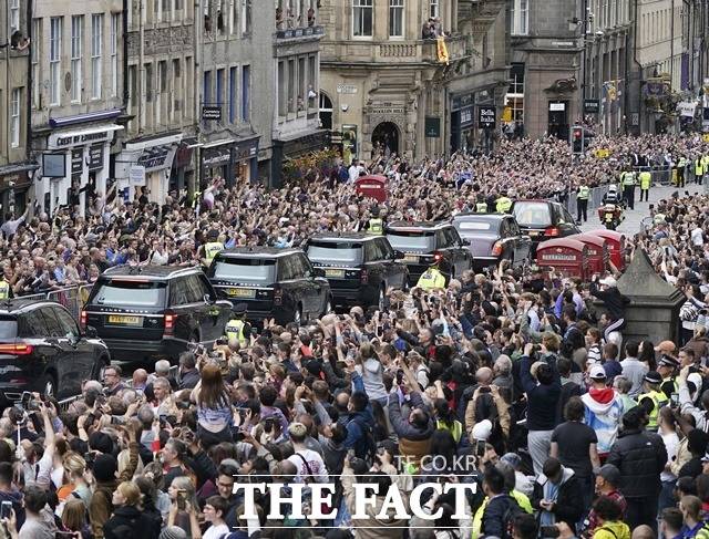 지난 11일(현지시간) 영국 에든버러에서 시민들이 홀리루드하우스 궁전으로 향하는 엘리자베스 2세 여왕의 운구 행렬을 지켜보는 시민들. /에든버러=AP/뉴시스
