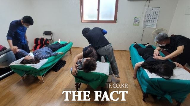 고흥군의 찾아가는 봉사서비스인 어깨동무봉사단의 일원인 물리치료반원들이 노인들을 상대로 물리치료를 하고 있다. /고흥군 제공