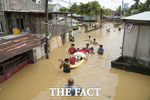 제16호 태풍 노루가 26일(현지시간) 필리핀 불라칸주 산미겔 마을에 상륙한 가운데 주민들이 세간살이를 보트에 싣고 고지대로 피신하고 있다. /불라칸=AP.뉴시스