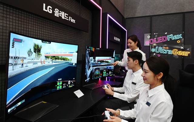 LG전자 모델들이 KES 2022 전시장에 마련된 벤더블 게이밍 OLED TV 플렉스를 활용해 게임 기능을 시연하고 있다. /LG전자 제공