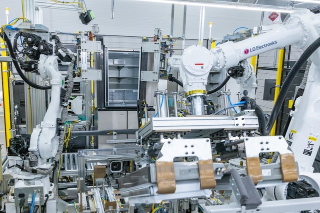 LG스마트파크 통합생산동 생산라인에 설치된 로봇팔이 20킬로그램(kg)이 넘는 커다란 냉장고 문을 들어 본체에 조립하고 있다. /LG전자 제공