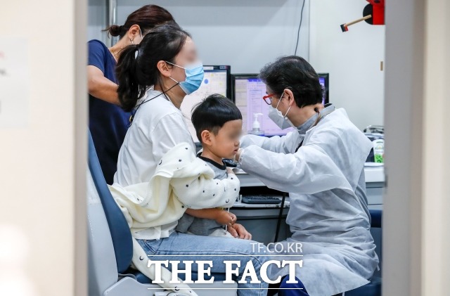 정부가 응급실 진료 전 필수로 시행하던 코로나19 검사를 의료진 판단으로 결정하도록 지침을 개정한다. 사진은 서울의 한 소아청소년과의원을 찾은 어린이가 독감 예방주사 접종을 받고 있다./뉴시스
