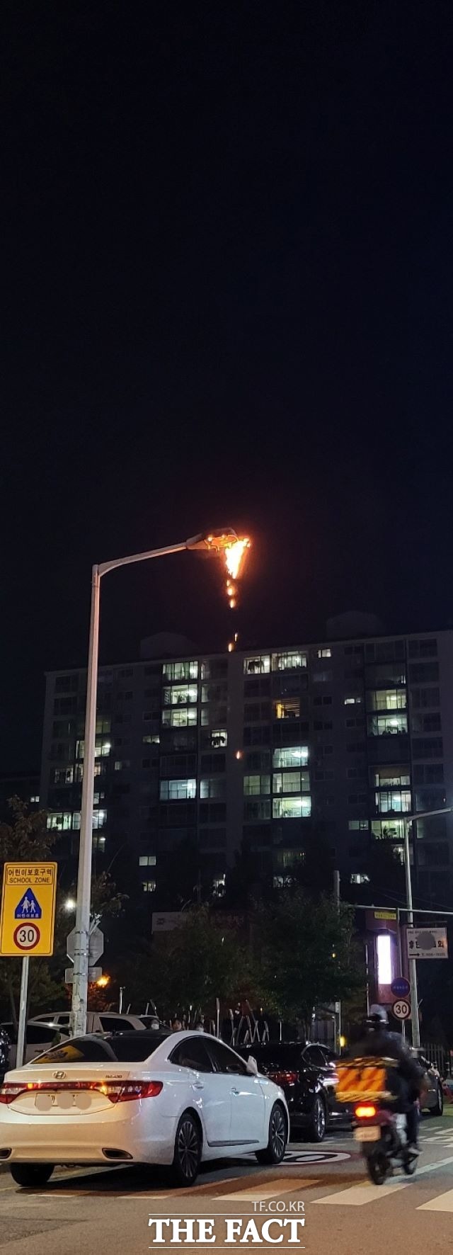 가로등 전구부가 녹아내리면서 도로 가장자리에 주차된 차량으로 불똥이 쉴 새 없이 떨어지고 있다. / 제보자 제공