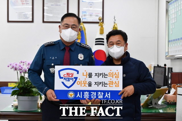 경기 시흥경찰서가 31일 전화금융사기 피해를 예방한 A씨를 경기남부경찰청 ‘피싱지킴이’로 선정, 표창장과 감사패를 전달하고 기념촬영을 하고 있다./시흥경찰서 제공