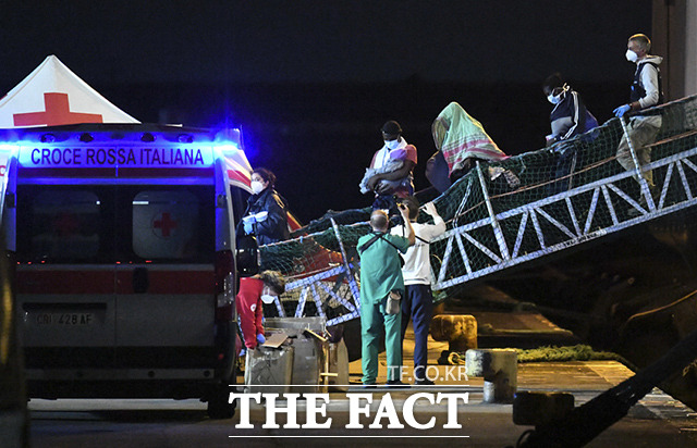 이탈리아 정부는 구조선들의 입항은 거부한 채 인도적인 차원에서 여성, 어린이, 부상자 등 취약자들의 하선을 허용했다. 6일(현지시간) 국경 없는 의사회가 운영하는 지오 바렌츠에 있던 난민 572명 중 357명이 배에서 내리고 있다. /시칠리아=AP.뉴시스