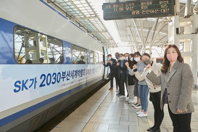SK이노베이션 구성원들이 KTX 래핑 열차 앞에서 2030부산세계박람회 유치를 응원하고 있다. /SK이노베이션 제공