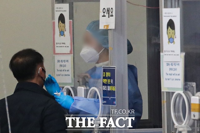 국내 코로나19 신규 확진자가 6만6587명 발생했다. 사진은 서울의 한 선별진료소에서 시민이 코로나 검사를 받고 있다./뉴시스