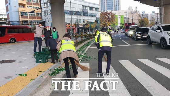 17일 오전 7시 42분쯤 고사장인 이사벨고 정문 앞에서 화물차에서 술병이 우르르 쏟아졌다. 이에 경찰은 유리조각을 신속하게 수거했고 운전자에겐 적재물추락방지조치위반 스티커를 발부했다. /부산경찰청 제공.