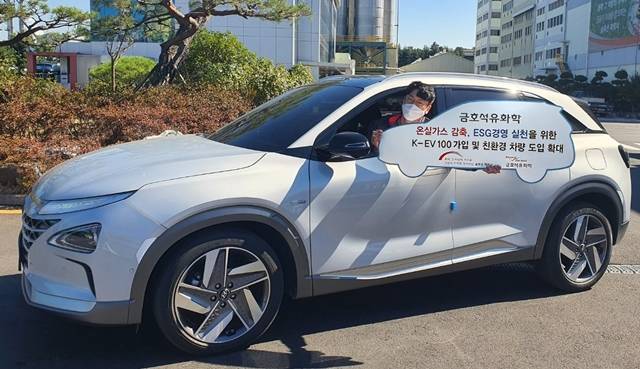 금호석유화학 울산 사업장 직원이 친환경 업무용 차량에 탑승해 한국형 무공해차 전환 100 참여 소식을 알리고 있다. /금호석유화학 제공