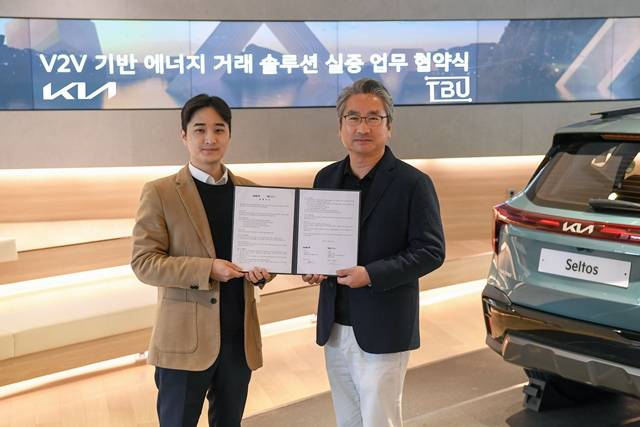 백상진 티비유(TBU) 대표(왼쪽)와 윤승규 기아 국내eBiz솔루션 실장(오른쪽)이 21일 서울 압구정동에 위치한 기아 360에서 차량간(V2V, Vehicle to Vehicle) 급속 충전 신기술 기반 에너지 거래 솔루션 실증을 위한 업무협약을 체결한 뒤 사진 촬영을 하고 있다. /기아 제공