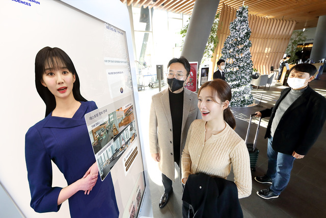 KT 모델이 노보텔 앰배서더 서울 동대문 호텔＆레지던스 1층 로비에 설치된 AI 컨시어지 앞에서 호텔 서비스 안내를 받고 있다. /KT제공