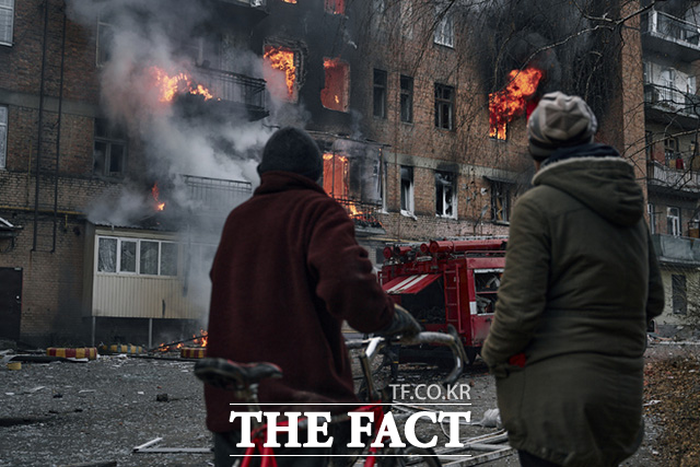 7일(현지시간) 우크라이나 도네츠크주 바흐무트에서 주민들이 러시아군의 포격으로 불타는 아파트를 바라보고 있다. /바흐무트=AP.뉴시스