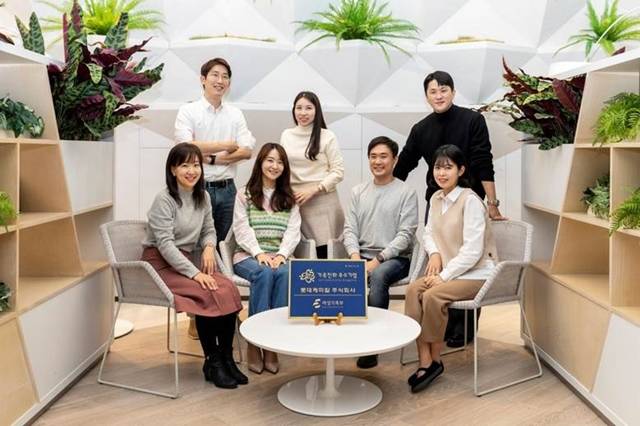 육아휴직을 사용한 롯데케미칼의 직원들이 모여 가족 친화 기업 인증 소식을 알리고 있다. /롯데케미칼 제공