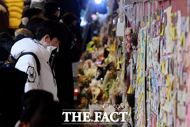 16일 오후 서울 용산구 이태원참사 사고 현장을 찾은 시민들이 벽을 가득채운 추모 메시지를 바라보며 희생자들의 넋을 기리고 있다. /이선화 기자