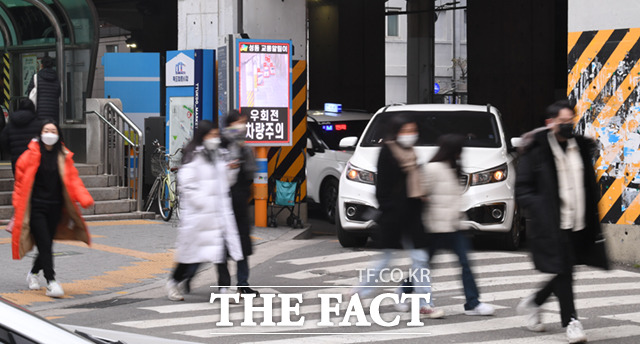 13일 오후 서울 성동구 성수역 앞 우회전 교차로에서 시민들이 보행하는 가운데, 우회전 차량이 정차하고 있다.