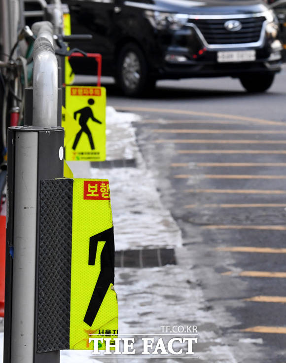20일 오후 서울 을지로입구역 앞 우회전 교차로에서 우회전 차량이 진입하는 가운데, 우회전 시 일단멈춤 안내 표지판이 파손돼 있다.