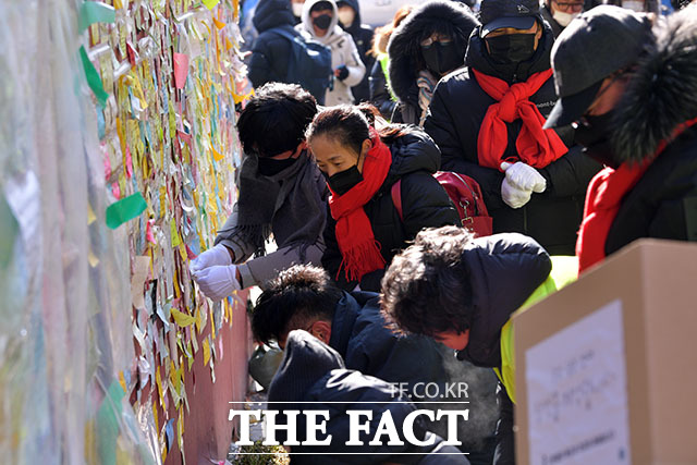 유가족과 이태원 상인, 시민 활동가들이 얼어붙은 조화를 떼고 메시지를 정리하고 있다.