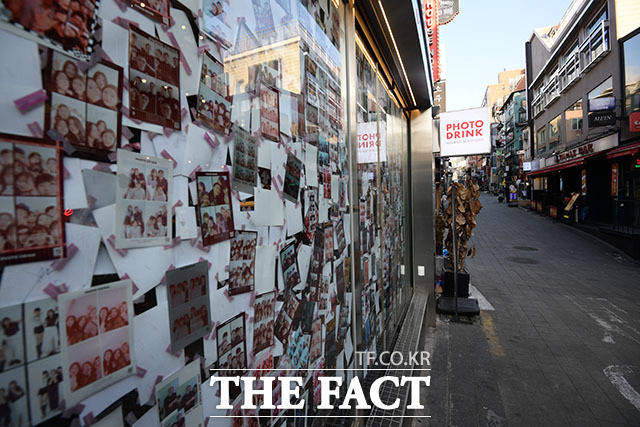 젊은이들이 찾았던 셀프 사진관 벽에 남은 기념사진과 텅 빈 거리가 대조를 이루고 있다.