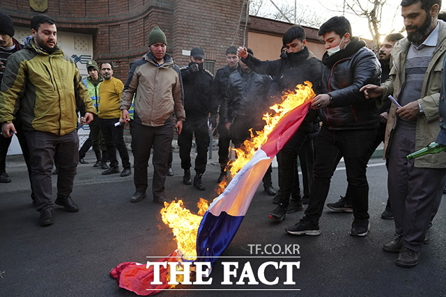 8일(현지시간) 이란 수도 테헤란의 프랑스 대사관 앞에서 시위대가 프랑스 주간지 샤를리 에브도에 실린 이란 최고 지도자 아야톨라 알리 하메네이의 풍자만화에 항의하는 의미로 프랑스 국기를 불태우고 있다. /테헤란=AP.뉴시스