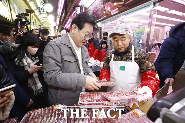이재명 더불어민주당 대표가 18일 오후 서울 마포구 망원시장을 방문해 식료품을 구매하고 있다. /이동률 기자