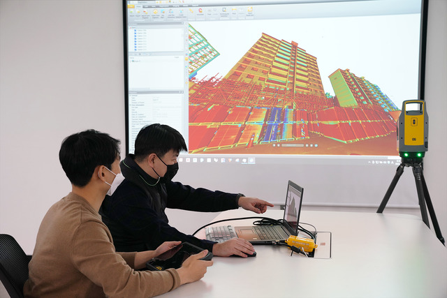 롯데건설 관계자가 3D 스캐너를 활용한 기존 아파트 모델링 데이터를 확인하고 있다. /롯데건설 제공