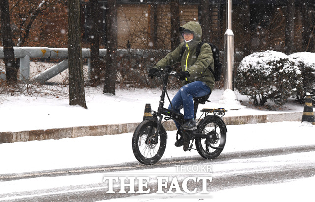 서울을 비롯한 수도권에 대설주의보가 내려진 26일 오전 서울 서초구 일대에서 한 시민이 자전거를 이용해 이동하고 있다.